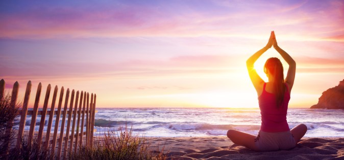 Woman Doing Yoga Fitness In The Beach At Sunset